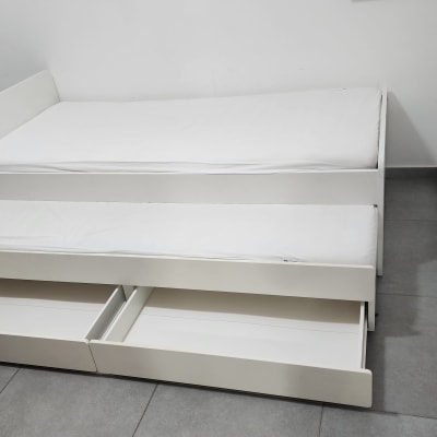 מיטה לבנה עם מגירות פתוחות בחדר ילדים
