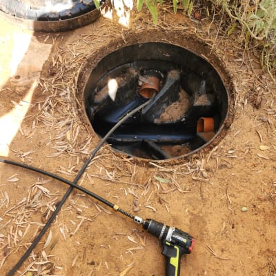 כלי עבודה ליד פתח ביוב פתוח בשטח חיצוני