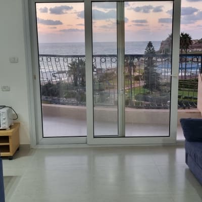 סלון עם ספה, תנור קטן ושקעי חשמל על הקיר