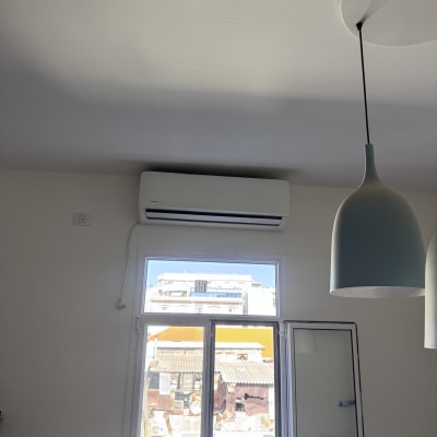 מזגן מותקן על קיר ליד חלון פתוח