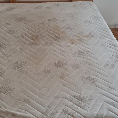 מזרן עם כתמים על רצפת אריחים