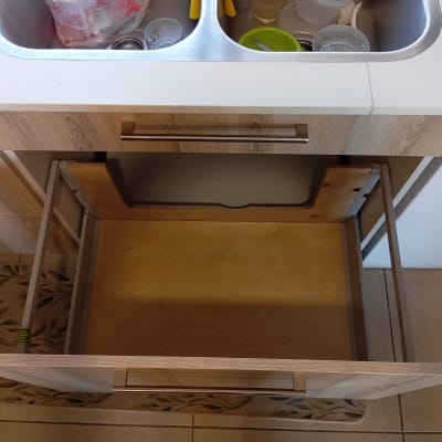 מגירה פתוחה מתחת לכיור במטבח