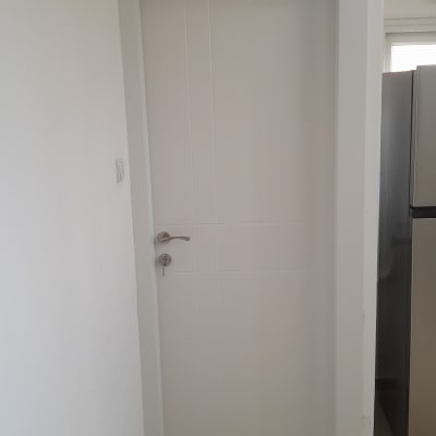 דלת לבנה עם ידית מתכת בחדר פנימי