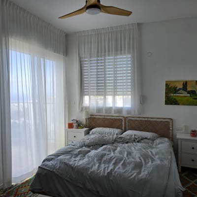 Bedroom with sheer white curtains on windows