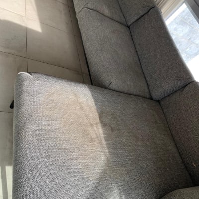 ספה אפורה עם כתם על הריפוד