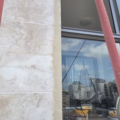 עבודת איטום וסגירת מרווחים בסנפלינג סביב חלון בחזית אבן