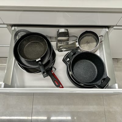 סירים ומחבתות מאורגנים במגירה במטבח מודרני