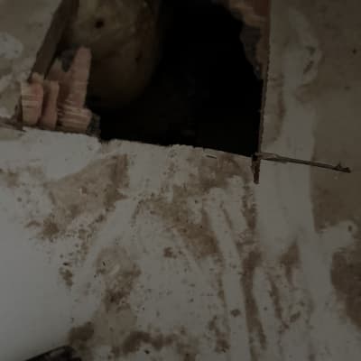 חור בקיר עם צינור חשוף ועבודת תיקון