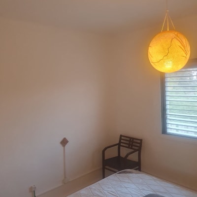 חדר עם קיר צבוע, מנורה תלויה, כיסא ומיטה