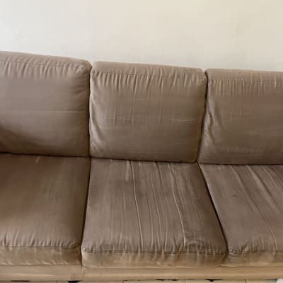 ספה חומה עם שלושה מושבים על רקע קיר לבן