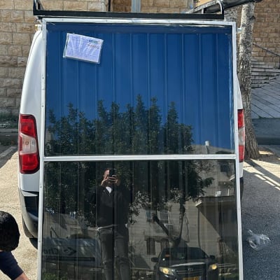 פאנל סולארי מונח על רכב עם אדם מתקין