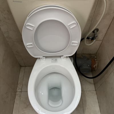 אסלה עם חיבורי צנרת ומיכל הדחה