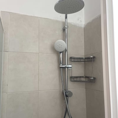 ראש מקלחת וכיור בחדר אמבטיה