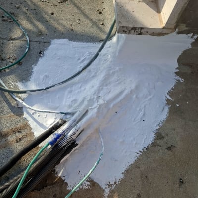 איטום עם חומר לבן סביב צינורות על גג