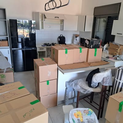 ארגזים מסודרים במטבח עם מוצרי אריזה וארגון