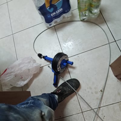 כלי עבודה של אינסטלטור על רצפה עם כבל מתכת