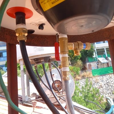 חיבורים וצינורות מתחת לדוד שמש על גג