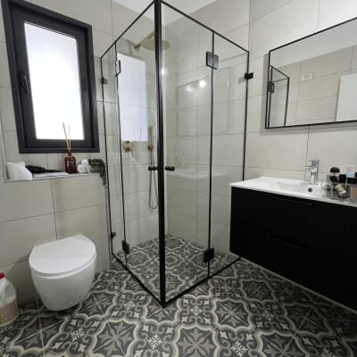 מקלחון זכוכית עם מסגרת שחורה בחדר אמבטיה מודרני