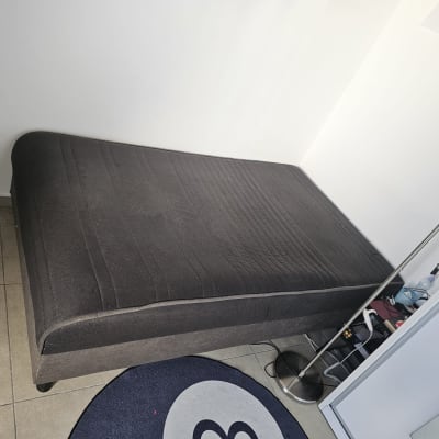 מיטה בחדר עם שטיח ומנורה עומדת