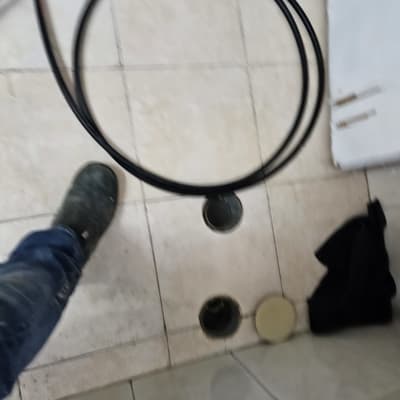 צינור שחור על רצפת אריחים עם חורים פתוחים