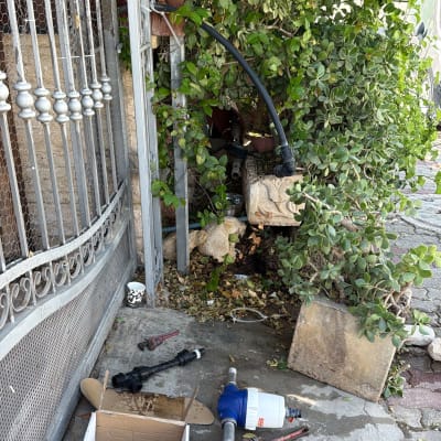 כלי עבודה ומסנן מים במהלך עבודת אינסטלציה בגינה