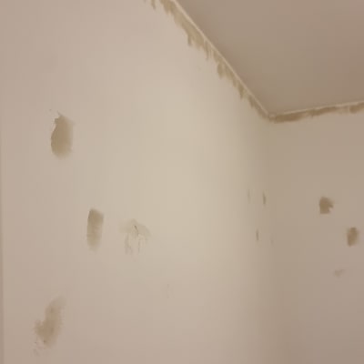 קיר עם תיקוני טיח וכתמי צבע