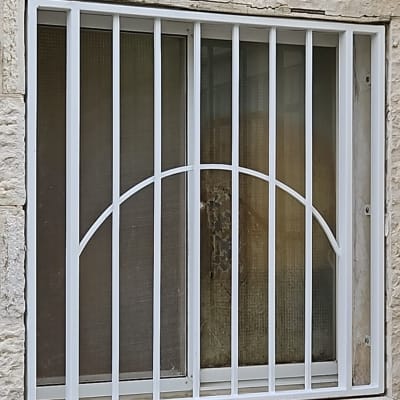 סורגי מתכת לבנים על חלון זכוכית