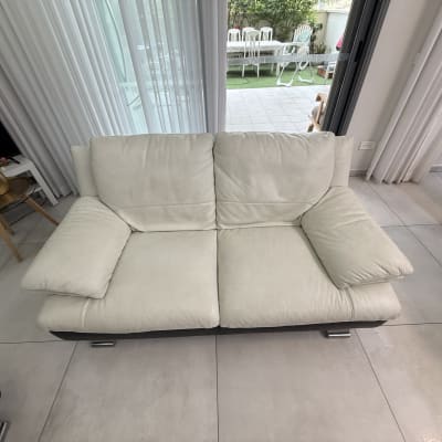 ספה לבנה בחדר מגורים עם רצפת אריחים בהירים