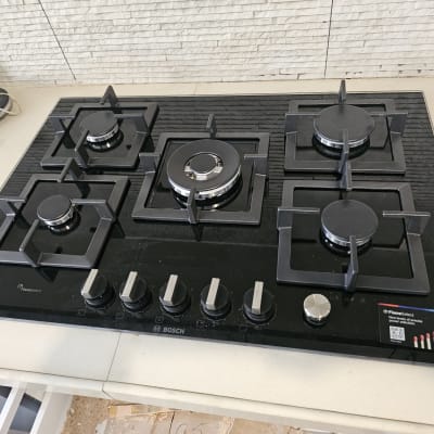 כיריים גז שחורות עם חמישה מבערים וכפתורי שליטה