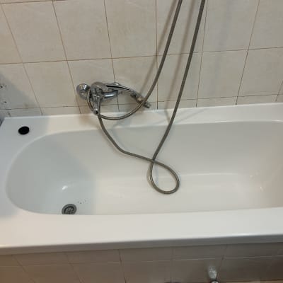 אמבטיה עם ברז ומקלחת על קיר מרוצף