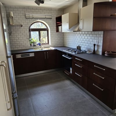 מטבח מודרני עם ארונות עץ, כיריים ותנור