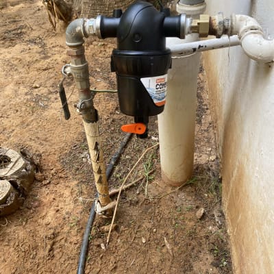 מסנן מים מותקן על צינור חיצוני ליד קיר