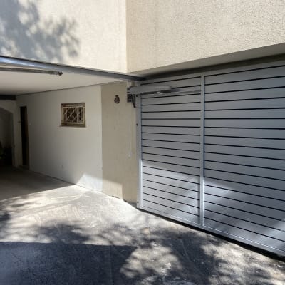 שער חשמלי מתכת אפור בכניסה לחניה