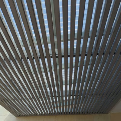 פרגולה מעץ עם קורות אופקיות מעל חלון