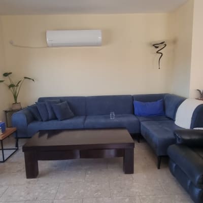 סלון מרוהט מרווח עם קירות צבועים בגוון שמנת אחיד