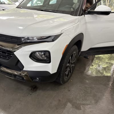 רכב לבן עם דלת פתוחה במוסך