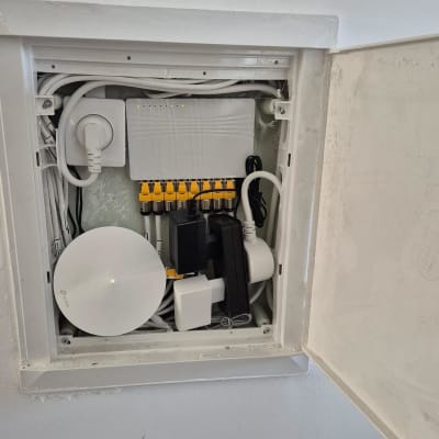 ארון תקשורת עם נתב, כבלים ומפצל רשת