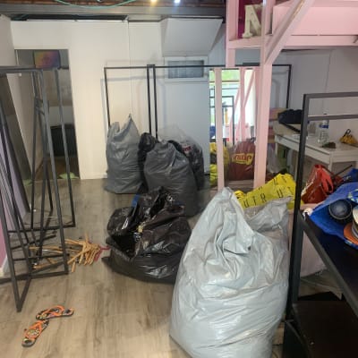 שקיות אשפה ופריטים מפוזרים בחדר עם קירות ורודים