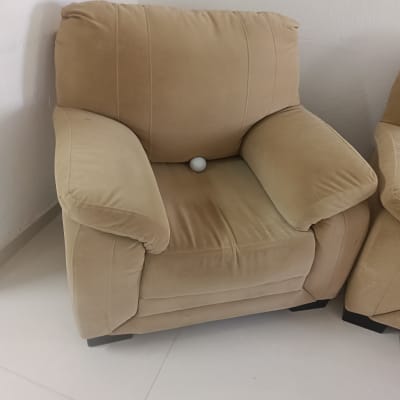 כורסה מרופדת עם כדור לבן על המושב