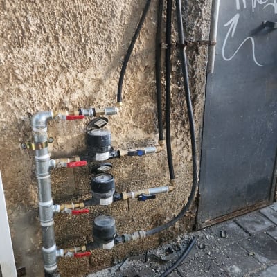 צינורות מים, ברזים, מונה מים, כלי עבודה על הרצפה