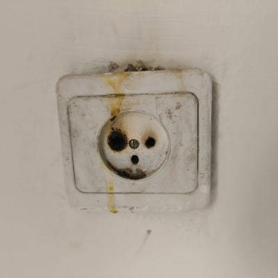 שקע חשמלי ישן ומלוכלך על קיר