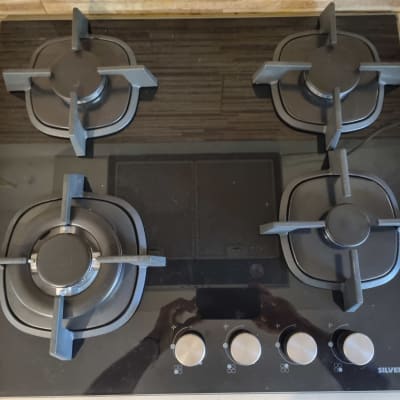 כיריים גז עם ארבעה מבערים וכפתורי שליטה.