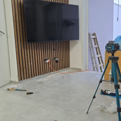 חדר בשיפוץ עם כלים, טלוויזיה על קיר עץ, סולם