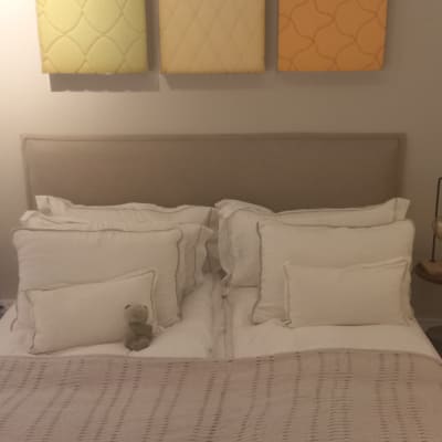 מיטה עם כריות ולוח קיר מעוצב