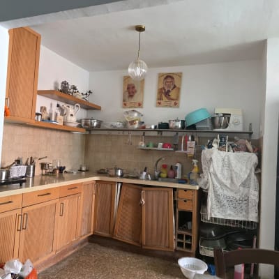 מטבח ישן עם ארונות עץ וכלים שונים
