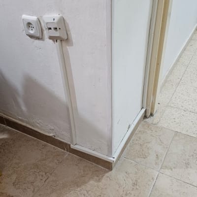 שקע חשמל וכבל רשת על קיר לבן