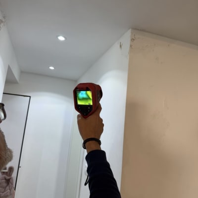 אדם מחזיק מצלמה תרמית לבדיקת קיר פנימי