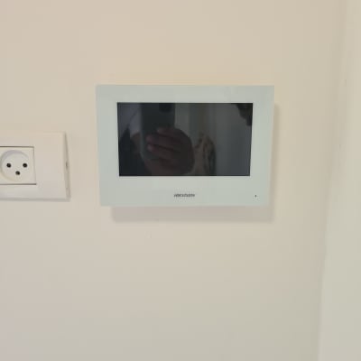 מסך אינטרקום מותקן על קיר לבן