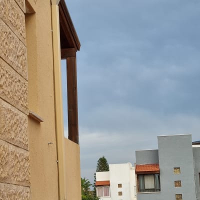 גג רעפים אדום עם מרזב צמוד לקיר