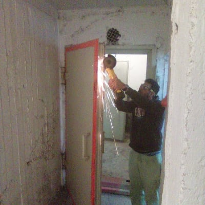 אדם משתמש בכלי חיתוך על דלת